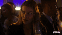 a woman drinking from a glass with netflix written on the bottom