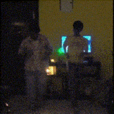 a couple of people standing in a room with green lights