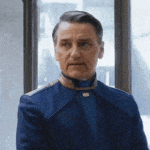 a man in a blue uniform is looking at the camera