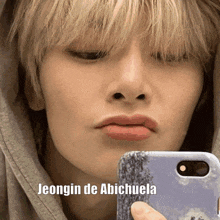 a close up of a person taking a selfie with the words jeongin de abichuela below