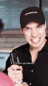 a man wearing a starbucks hat is smiling and holding a bottle