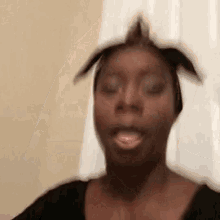 a woman with a mohawk on her head is making a funny face with her mouth open .