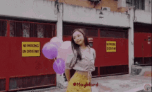 a girl holding balloons in front of a no parking sign