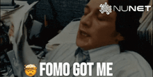 a man in a suit and tie says " fomo got me " in front of a nunet logo