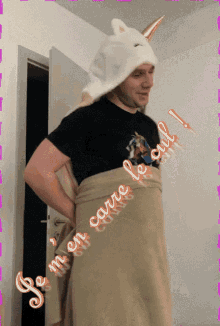 a man wearing a unicorn hat is wrapped in a blanket with the words je m en carre le cul