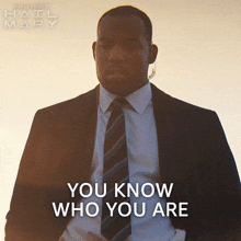 a man in a suit and tie with the words " you know who you are "