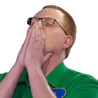 a man wearing glasses and a green shirt covering his mouth