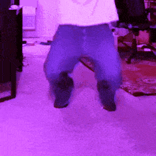 a person is dancing in a room with purple lighting