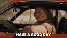 a man sitting in a car with the words have a good day below him