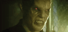 a close up of a man with red eyes looking at the camera .