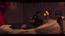 a person in a red jumpsuit is standing in front of a table with candles and a sign that says fra