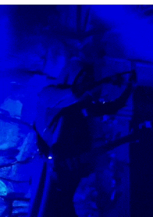 a person is standing in a dark room with blue lights behind them