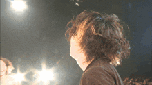 a close up of a person 's hair with a crowd behind them