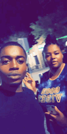 a man and a woman are posing for a picture while the man is wearing a shirt that says good vibes