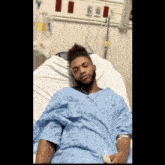 a man is laying in a hospital bed with a drip in his arm