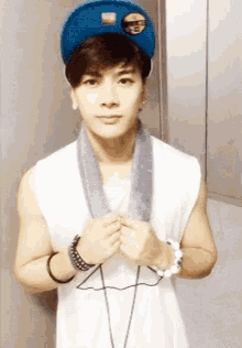 a boy wearing a blue hat and a white tank top