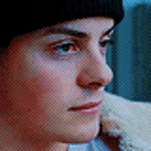 a close up of a man 's face wearing a black beanie .