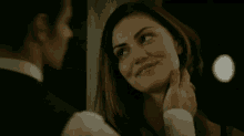 a man in a tuxedo touches a woman 's face
