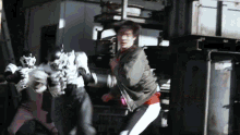 a man in a bomber jacket is being attacked by a monster