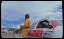 a man is standing next to a car that has the letter h on it