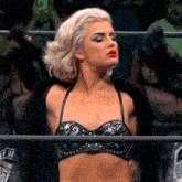 a woman in a black bra is standing in a ring with a shirt that says ' t.u.f. '