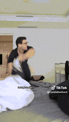 a man is laying on a bed with a tiktok watermark on the bottom
