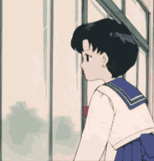 a girl in a sailor uniform looks out a window .
