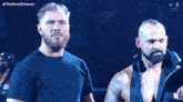 a man with a beard is standing next to a woman in a wrestling ring