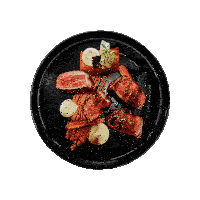 a black plate topped with meat and vegetables with a white background