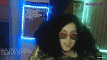 a woman wearing red sunglasses is standing in front of a sign that says happy halloween