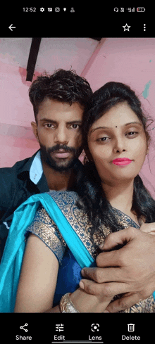 a man and woman are posing for a picture on a cell phone