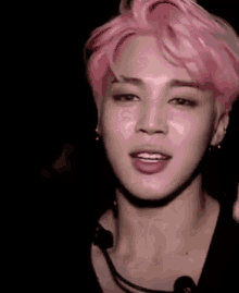 a close up of a person 's face with pink hair and a microphone .