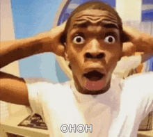a man with a surprised look on his face is holding his hands to his ears .