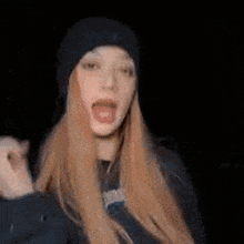 a woman with long red hair is wearing a black hat .