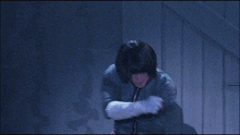 a woman in a green jacket and white gloves is standing in a dark room