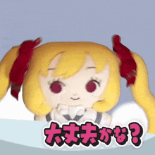 a stuffed doll with yellow hair and red ribbons has a sticker that says ' eee ? ' on it