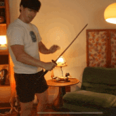 a man is holding a sword in a living room