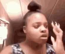 a woman with long nails is making a funny face while looking at herself in a mirror .