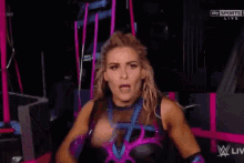 a woman in a wrestling outfit is making a funny face while standing in a room .