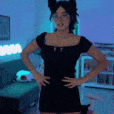 a woman in a black dress with glasses and cat ears stands in front of a sign that says wow