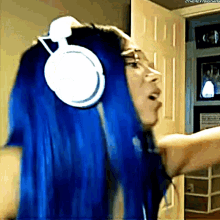 a woman with blue hair is wearing headphones and has the word " the next thing " on the bottom right