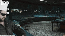 a man wearing a white hat and sunglasses is in a room with a hbo logo on the bottom