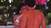 a man and a woman are standing next to each other in a pool .