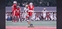 a football player with the number 5 on his jersey is being tackled by another player