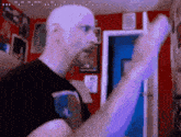 a man with a beard is standing in a room with a red wall and a blue door .