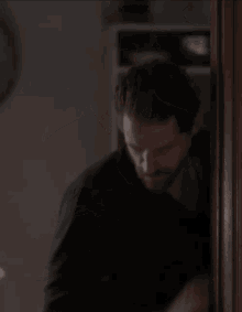 a man in a black shirt looks at his phone