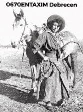 a black and white photo of a woman standing next to a horse with the words 0670entaxim debrecen written above her