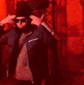 a man in a black jacket is standing in front of a row of red lights