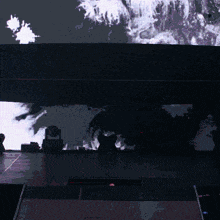 a stage with a large screen behind it that has a painting on it