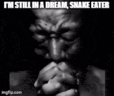 a black and white photo of a man praying with a caption that says i 'm still in a dream snake eater